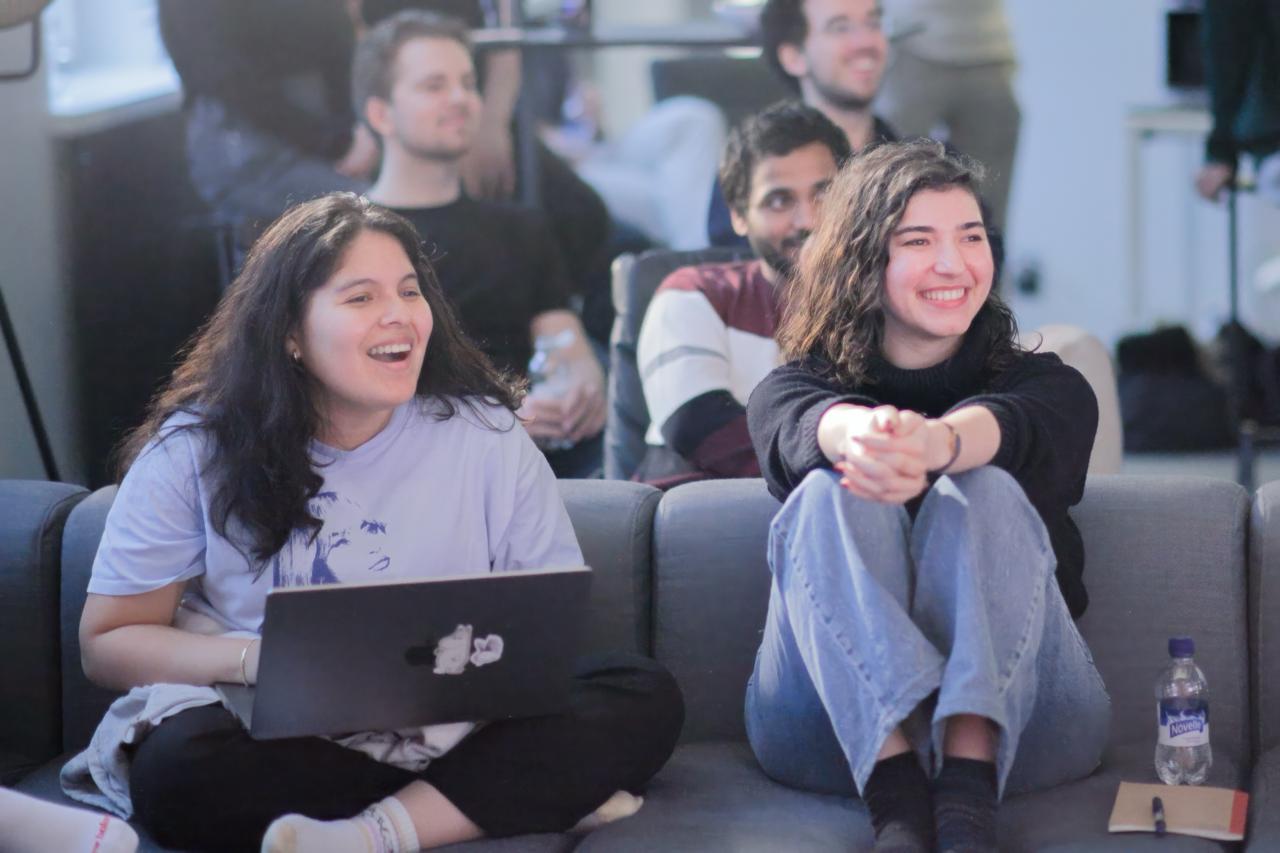 Two community members laughing together on a couch