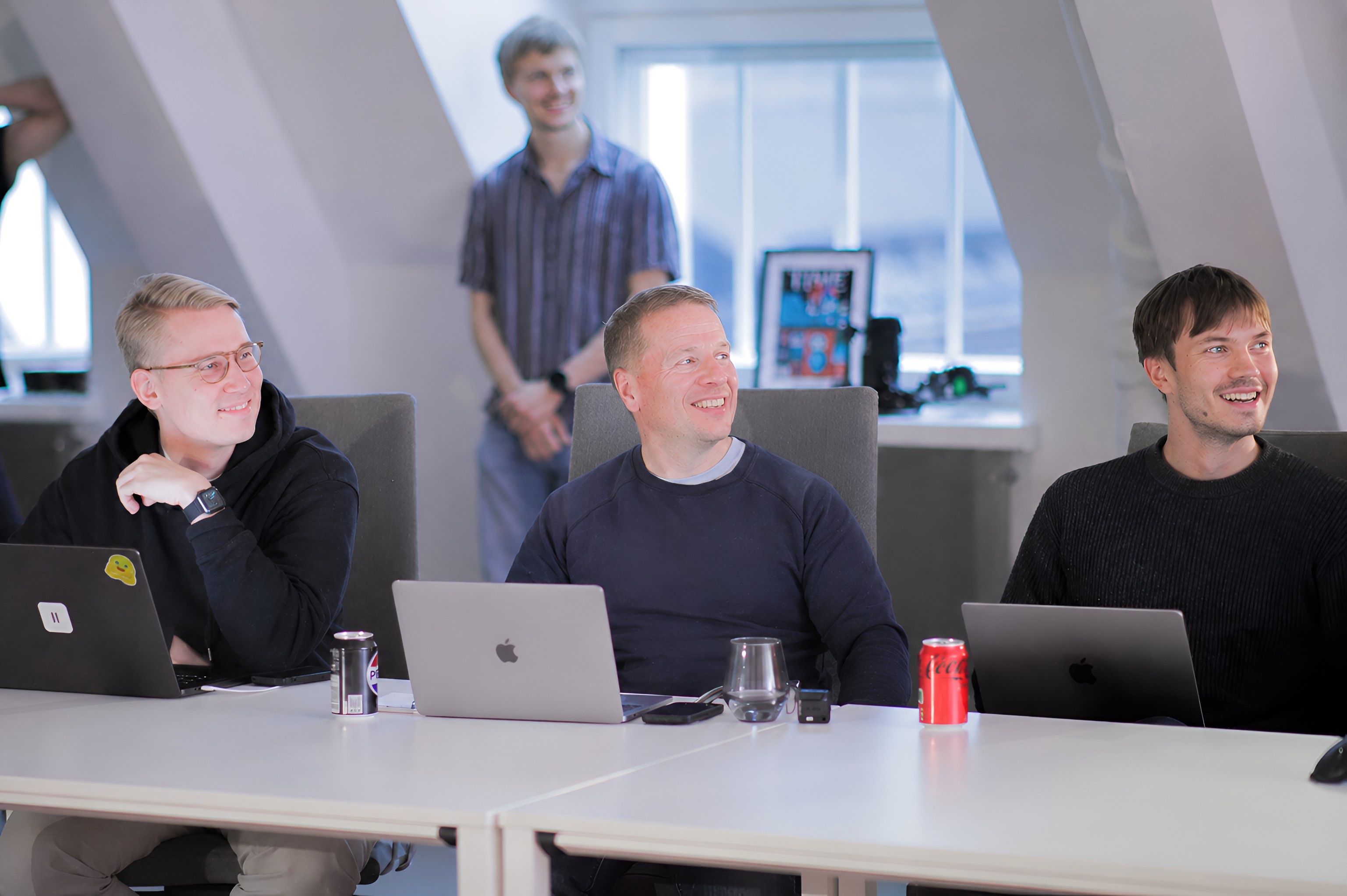 Members working together on laptops around a table